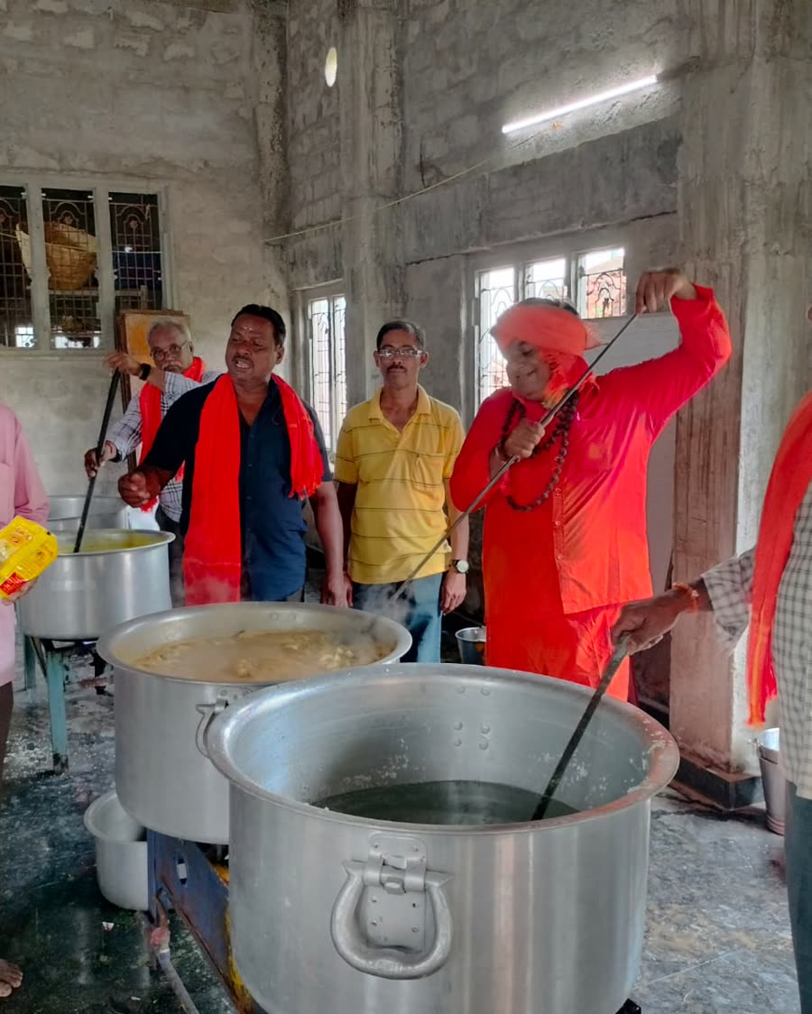 Volunteers at the large steel vessels of sambar, before the serving begins