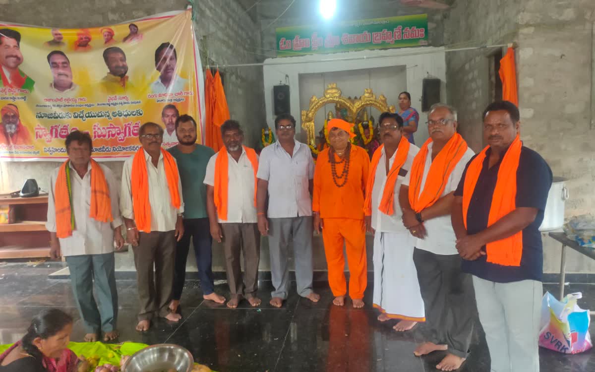 Volunteers and Guruji standing together in the hall in front of the shrine