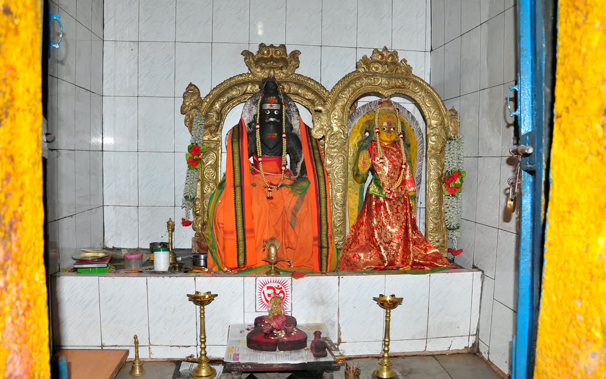 Garlanded idols in a gilded arch inside a small sanctum